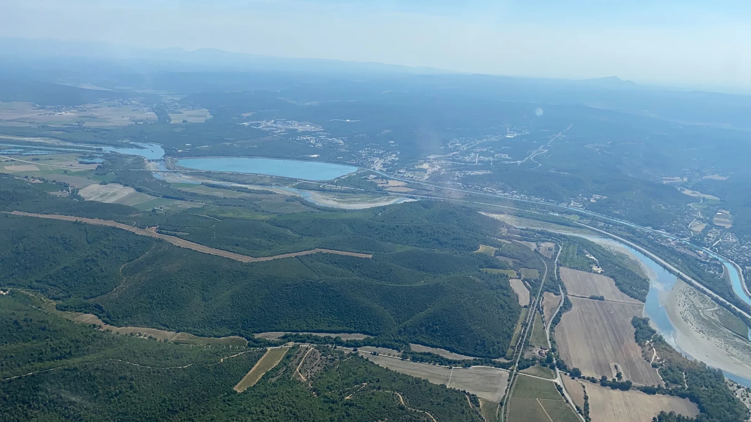 Survol des collines et d'un lac de Provence en hélicoptère