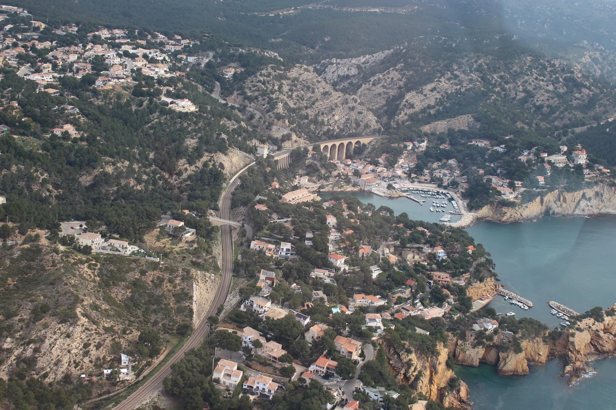 Vue aérienne d'un village côtier méditerranéen depuis un hélicoptère du Rotor Club Aixois